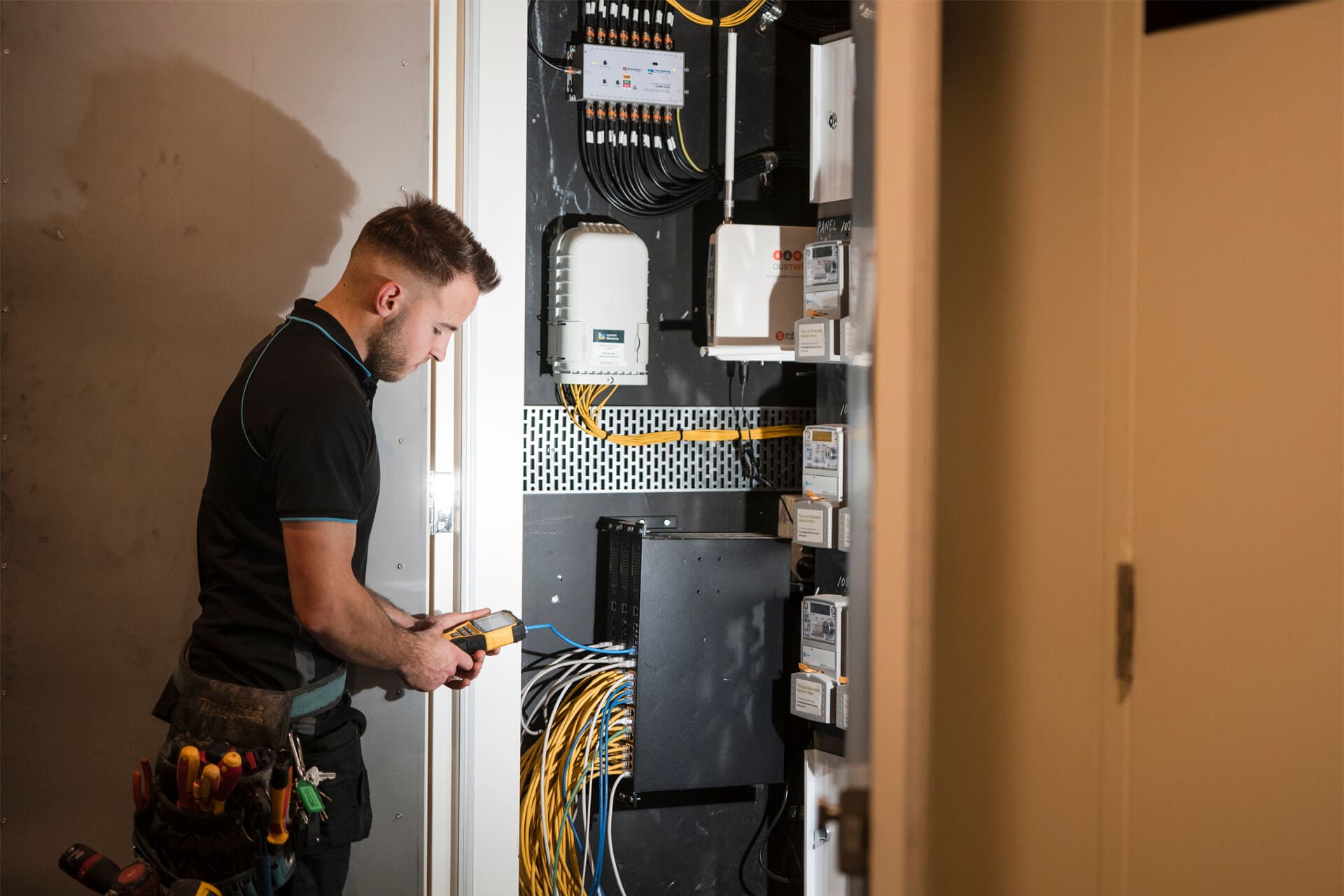 Electrician testing electrical panel with multimeter